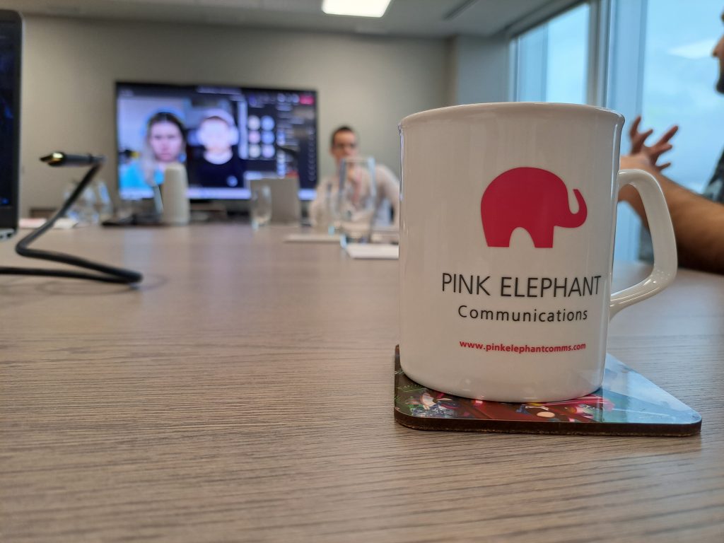 communication with journalists, pink elephant mug on a table