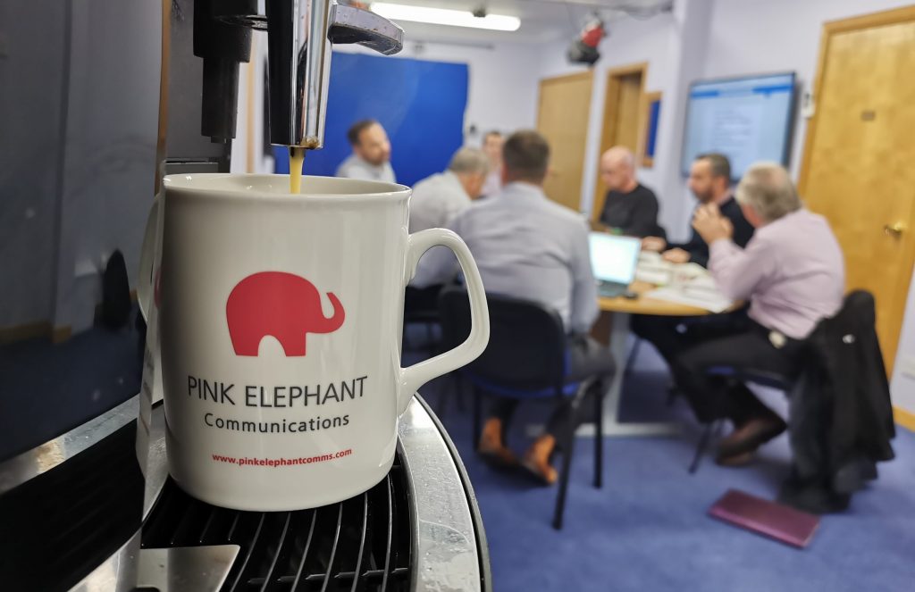customer communication, pink elephant mug, boardroom with people
